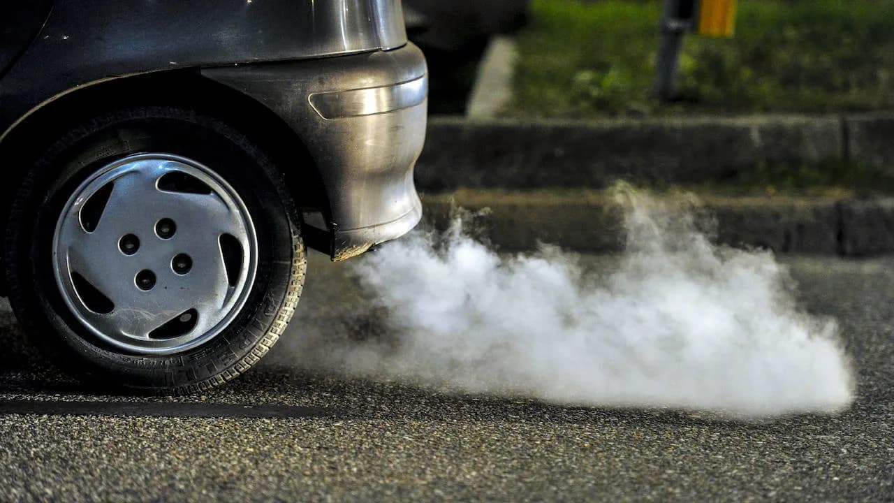 Tubo de escape de un coche de combustión expulsando humo