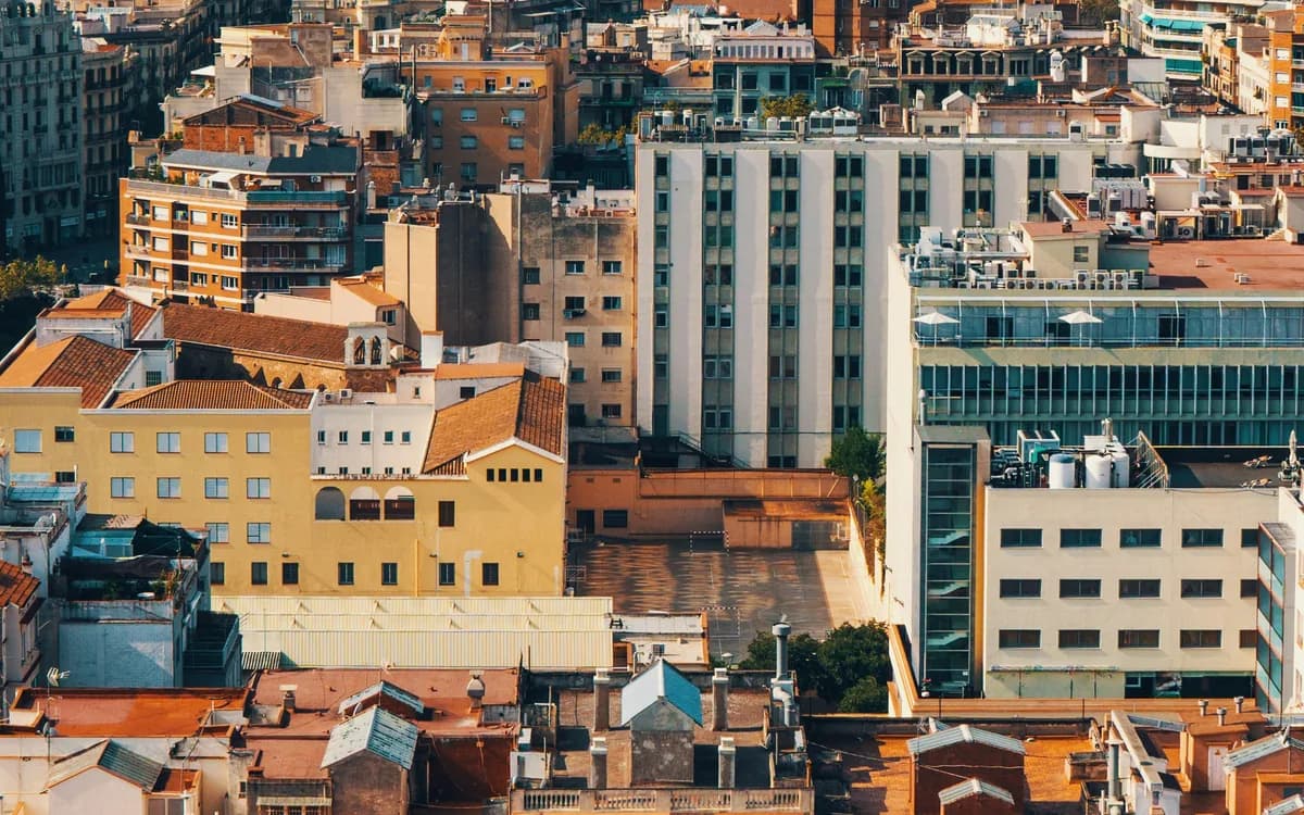 Azoteas y cubiertas de bloques de viviendas de una ciudad española, con la luz cálida del atardecer.