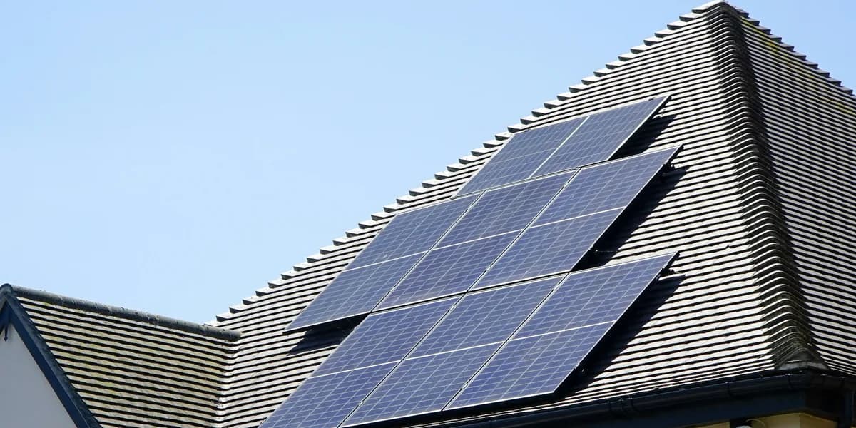 Placas solares fotovoltaicas instaladas sobre el tejado inclinado de una vivienda unifamiliar.
