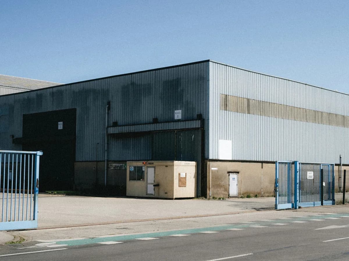 Nave industrial en un polígono, con cubierta metálica y muelles de carga.